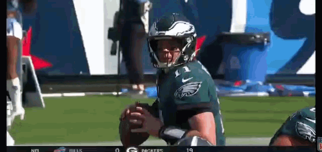 a football player wearing a green jersey with the eagles on it