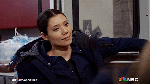 a woman in a blue jacket is sitting in an ambulance with a nbc logo in the corner