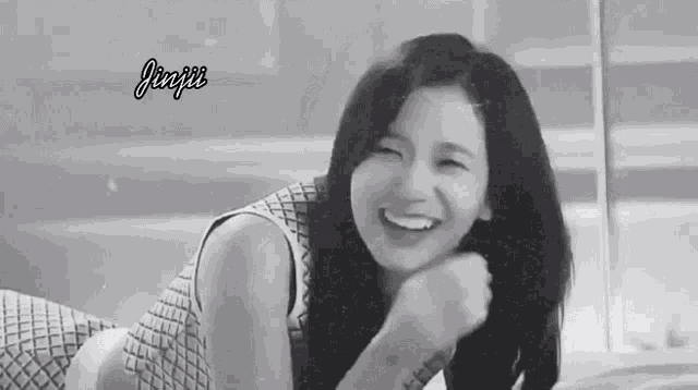 a black and white photo of a woman laughing .