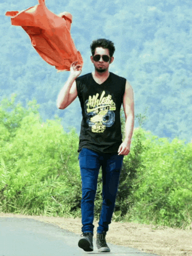 a man wearing a black tank top that says athletes