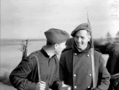 a group of soldiers are standing next to each other and talking .