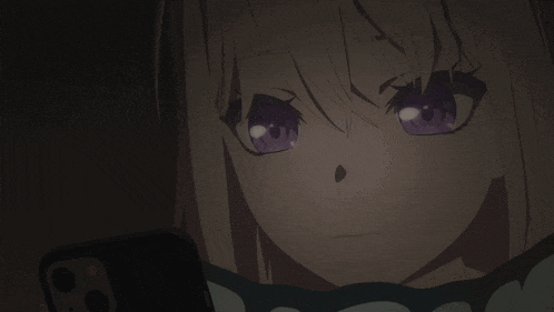a close up of a girl with purple eyes looking at a cell phone