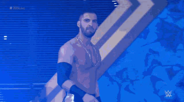 a shirtless man is standing in front of a blue wall with a question mark in the background