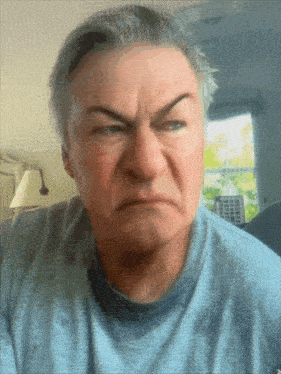 a man in a blue shirt is making a face