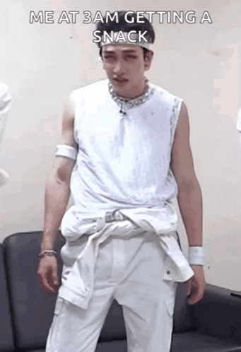 a man in a white tank top and white pants is getting a snack