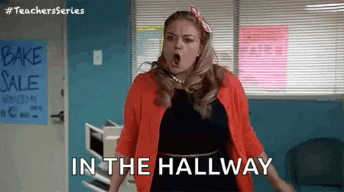a woman is standing in a hallway with her mouth open and the words `` in the hallway '' .