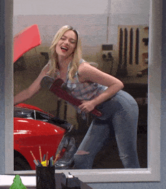 a woman holding a wrench in front of a red car with the hood open