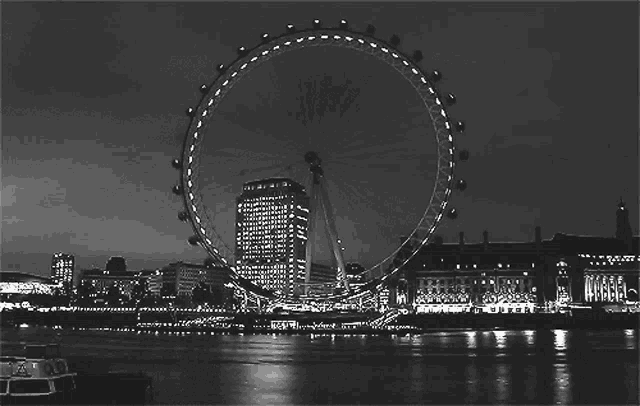 a black and white photo of a large ferris wheel