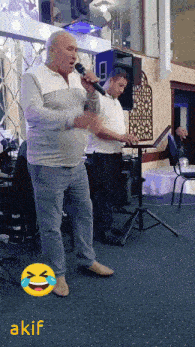 a man singing into a microphone with a smiley face behind him that says ' akif '