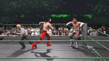 two wrestlers are in a ring with a referee in the background