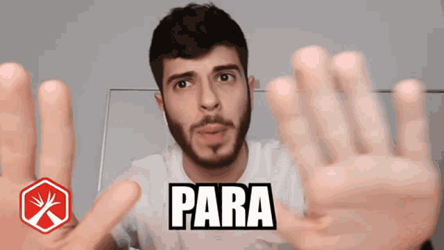 a man with a beard is making a stop gesture with his hands and the word para is visible behind him