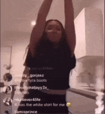 a woman in a black shirt is dancing in a kitchen