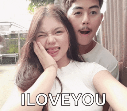 a man and a woman are posing for a picture and the woman is sticking her tongue out and the man is saying i love you