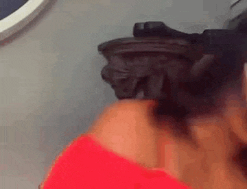 a woman wearing a red off the shoulder top and a visor is standing in front of a wall .