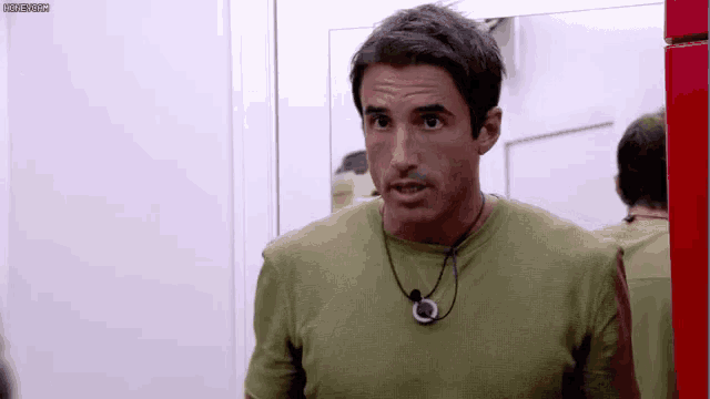 a man in a green shirt with a necklace around his neck