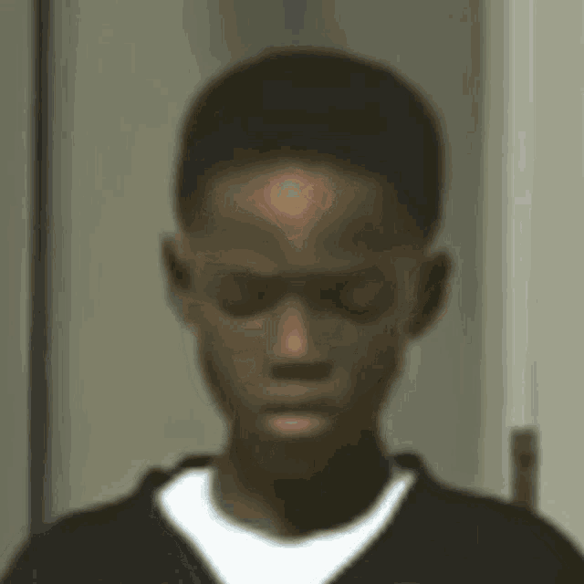 a blurred image of a young man with a circle on his forehead