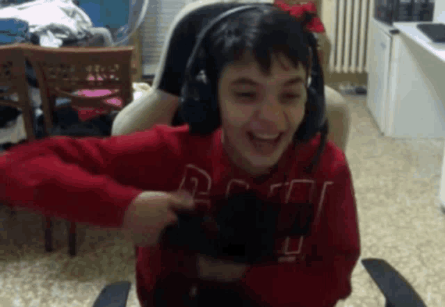 a young boy wearing headphones and a red sweatshirt with the letter r on it