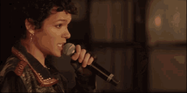 a woman singing into a microphone with the word shure on the front