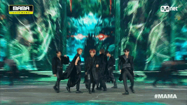 a group of men are dancing on a stage with the words mama on the bottom