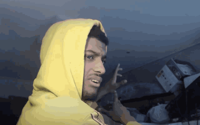 a man in a yellow hoodie with the word supreme on the front