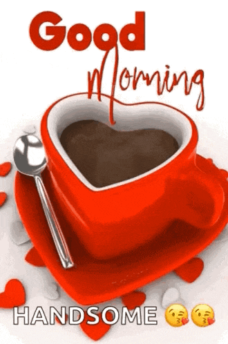 a red cup of coffee in the shape of a heart with a spoon on a saucer .