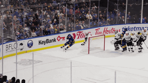 a hockey game is being played in front of a banner that says tim hortons