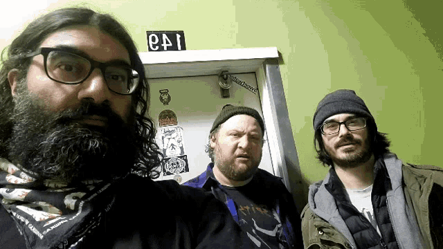 three men are standing in front of a door that says e41