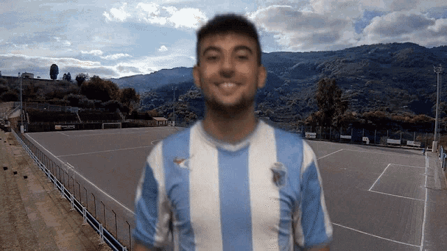 a man wearing a blue and white striped shirt is smiling