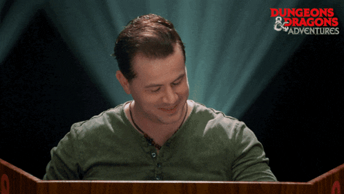 a man sitting at a podium with the words dungeons & dragons adventures behind him