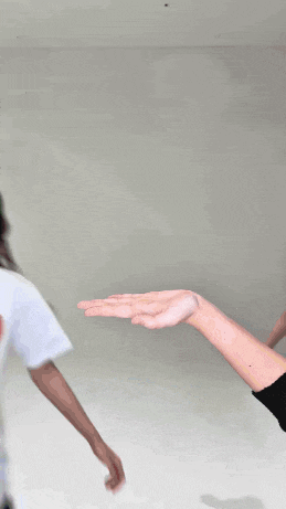 a woman wearing a white shirt with a red heart on it is being touched by another woman 's hand