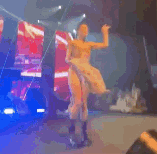 a naked woman is dancing on a stage with purple lights