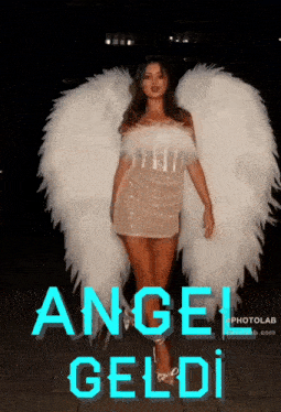 a woman in a white dress and white angel wings is standing in front of a sign that says angel geldi
