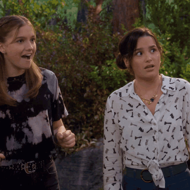two girls are standing next to each other and one has a necklace that says ' i love you ' on it