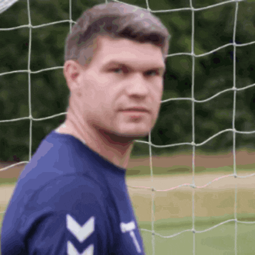 a man in a blue shirt with white arrows on the sleeves