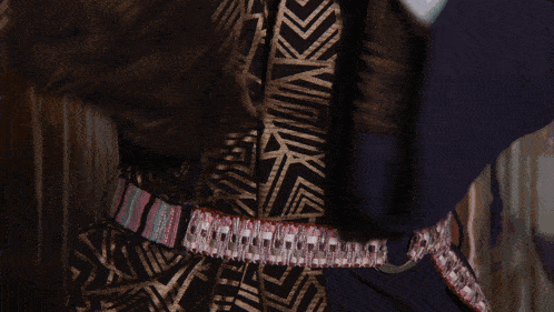 a close up of a person 's waist with a belt that has a pink and white stripe on it