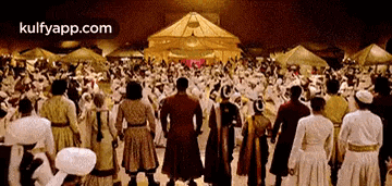 a large group of people are standing in front of a tent and holding hands .