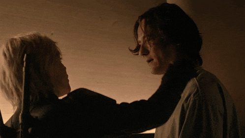 a man and a woman looking at each other in the dark