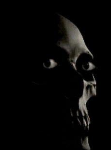 a black and white photo of a skull with its mouth open and eyes .