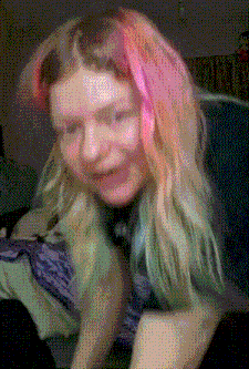 a girl with pink and green hair is smiling
