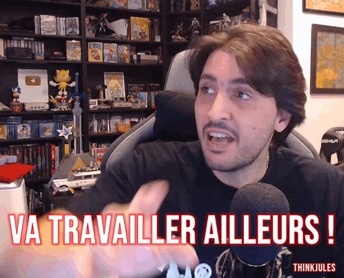 a man sitting in front of a microphone with the words va travailler ailleurs