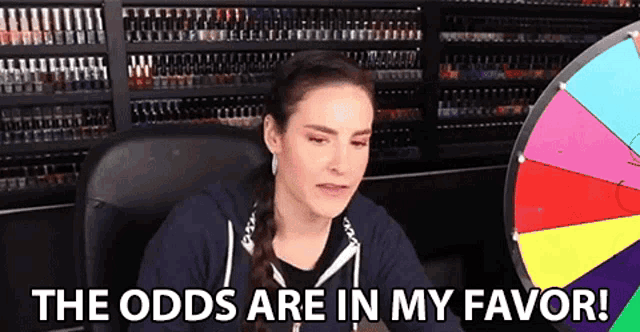 a woman is sitting in front of a spinning wheel and says `` the odds are in my favor '' .