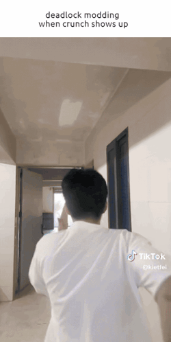 a man in a white shirt is walking down a hallway with a caption that reads deadlock modding when crunch shows up