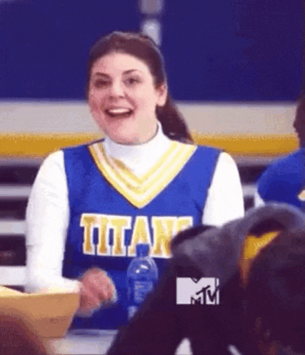 a cheerleader in a blue and yellow titans uniform is smiling .