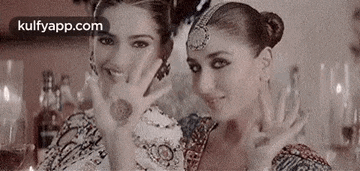 a couple of women are standing next to each other and making a funny face .
