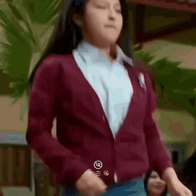 a girl in a school uniform is dancing in front of a crowd .