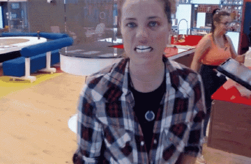 a woman in a plaid shirt is making a funny face with her mouth open