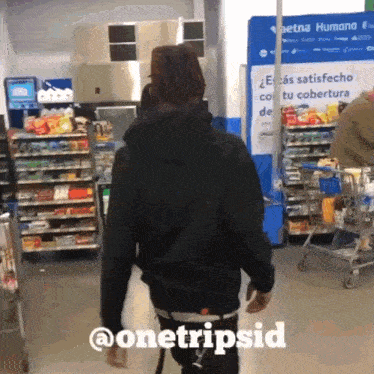 a man in a black hoodie is walking through a grocery store with the hashtag @onetripsid