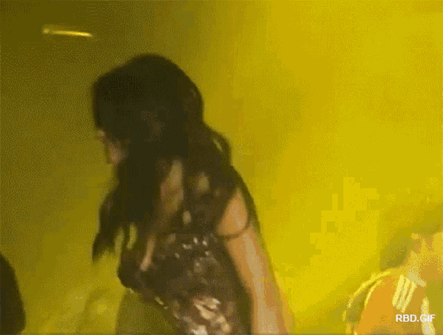 a gif of a woman dancing in front of a yellow background