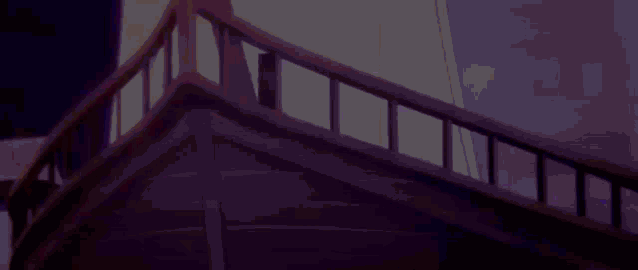 a close up of the side of a wooden boat with a purple sky in the background .