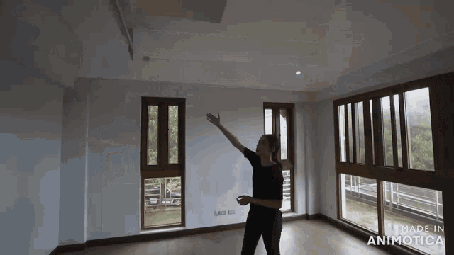 a woman is standing in an empty room with the words made in animatica on the bottom right